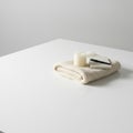 A folded blanket, a candle and a notebook on a white table. Space for text. Royalty Free Stock Photo