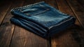 Folded blue jeans on a dark wooden surface in a studio setting Royalty Free Stock Photo