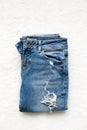 Folded blue jeans lie on a white background