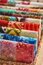 Folded bright pieces of quilting batik fabrics in a basket, macro