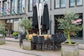 Folded cafe tables and chairs and closed sun umbrellas Royalty Free Stock Photo