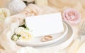 Folded Card near light pink fabric and cream flowers on plate close up, copy space, wedding mockup Royalty Free Stock Photo