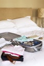 Folded Clothes And Packed Suitcase On Bed