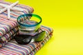 Folded Colorful Striped Organic Cotton Beach Towels, Blue Rim Glass with Water and Black Sunglasses on yellow background Royalty Free Stock Photo