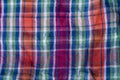 Folded crumpled multicolored checkered cotton fabric background texture