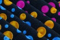 Folded fabric with red, blue, pink, gold and green dots / circles