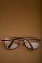 Folded glasses lie on a brown background Royalty Free Stock Photo