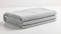 Folded gray towel made of microfiber fabric placed on a white surface Royalty Free Stock Photo
