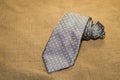 Folded grey tie on the old tissue Royalty Free Stock Photo