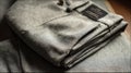 Folded Grey Trousers Displayed With a Visible Label on a Soft Surface in a Cozy Indoor Setting Generative AI Royalty Free Stock Photo