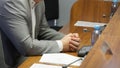 Folded hands of politician or businessman on desk next to documents, speakerphone and microphone. Working meeting with colleagues Royalty Free Stock Photo