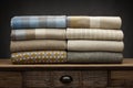 8 folded luxury throws shot on a wooden sideboard, with a grey background