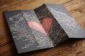 Folded map with a red heart drawing on a wooden surface Royalty Free Stock Photo