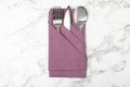 Folded napkin with fork, spoon and knife on marble background Royalty Free Stock Photo