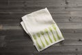 Folded Napkin with Green Fork Pattern on Wooden Surface