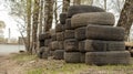 folded old car tires lie on the ground near the road, background