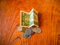 Folded One US dollar banknote and coins of different countries on a pile. On the top is an US quarter dollar Royalty Free Stock Photo