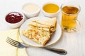 Folded pancakes, jam, honey, condensed milk, fork, cup of tea Royalty Free Stock Photo