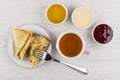Folded pancakes, jam, honey, condensed milk, fork, cup of tea Royalty Free Stock Photo