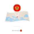 Folded paper map of Montenegro with flag pin of Montenegro Royalty Free Stock Photo