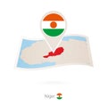 Folded paper map of Niger with flag pin of Niger