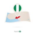 Folded paper map of Nigeria with flag pin of Nigeria Royalty Free Stock Photo