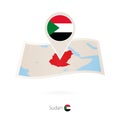 Folded paper map of Sudan with flag pin of Sudan