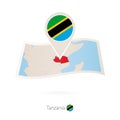 Folded paper map of Tanzania with flag pin of Tanzania Royalty Free Stock Photo