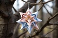 folded paper star of david ornaments hanging on tree branches Royalty Free Stock Photo