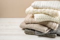 Folded pastel sweaters on white wooden table