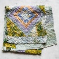 Folded patchwork scarf sewn from silk fabrics Royalty Free Stock Photo