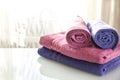 Folded purple and pink towels on a light background