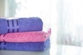 Folded purple and pink towels on a light background