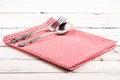 Folded red checkered tablecloth on a white wooden board