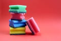 Folded scouring sponges in a single stack on a red background.