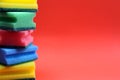 Folded scouring sponges in a single stack on a red background.