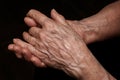 Folded senior woman wrinkled hands close up. Old age, age problems, poverty and loneliness theme