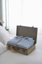 Folded Shirts In Open Suitcase On Bed Royalty Free Stock Photo