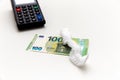 Folded shower cap or swimming cap for single use is on the 100 euro banknote on the white background. Cash register