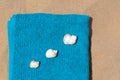 Folded soft blue beach towel with seashells on sand, flat lay Royalty Free Stock Photo
