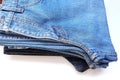 Folded stack jeans multicolor islolated on white background closeup. Royalty Free Stock Photo