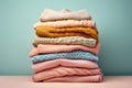 a folded stack of sweaters in pastel colors. Secondary clothing, reuse.