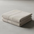 Folded stack of two beige towels on a smooth gray surface. The towels feature a subtl Royalty Free Stock Photo