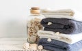 Folded towels near a bottle with seashells on a white wooden table. Spa and wellness, cotton terry textile. Ecological theme Royalty Free Stock Photo