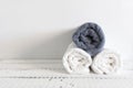 Folded two white and one grey towels on a white wooden table. Spa and wellness, cotton terry textile. Ecological theme Royalty Free Stock Photo