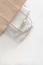 Folded two white towels in a paper bag on a white wooden table. Spa and wellness, cotton terry textile. Ecological theme Royalty Free Stock Photo