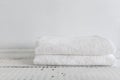 Folded two white towels on a white wooden table. Spa and wellness, cotton terry textile. Ecological theme Royalty Free Stock Photo