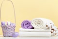 Folded white bed linen, rolls of towels basket with easter eggs on the table
