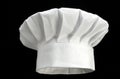 Folded white chef`s hat on a black background