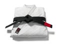 Folded white gi with black belt and red tag Royalty Free Stock Photo